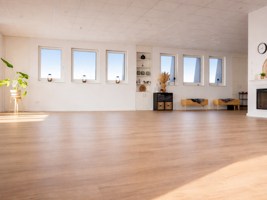 Helle, luftige Wohnraum mit Fenstern, Pflanzen und gemütlicher Sitzecke.