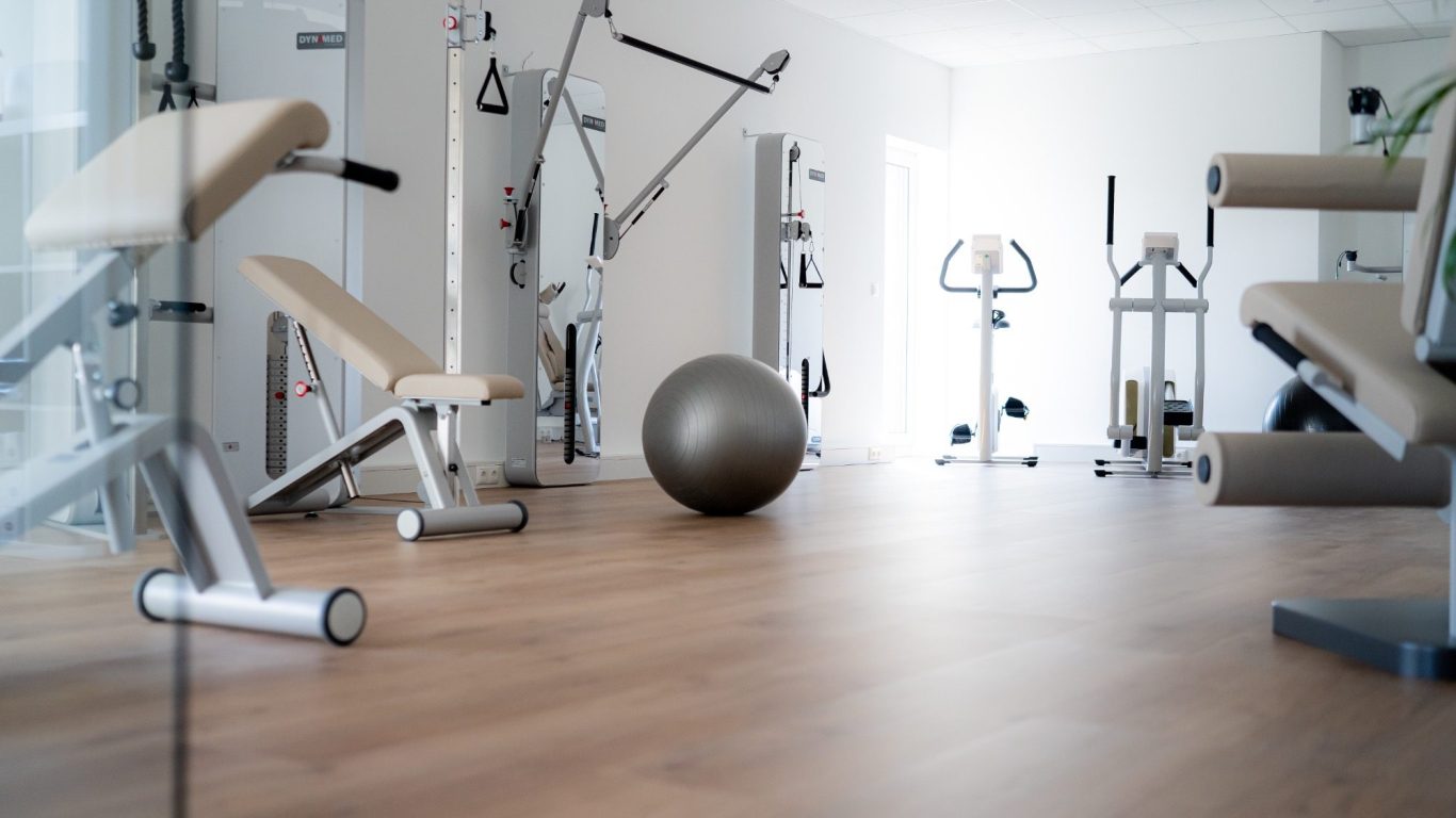 Moderne Fitnessgeräte in einem hellen Trainingsraum mit einem Gymnastikball.