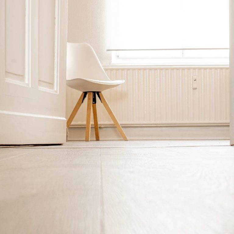 Zweistöckiges Haus mit roten Ziegeln und weißen Fenstern.