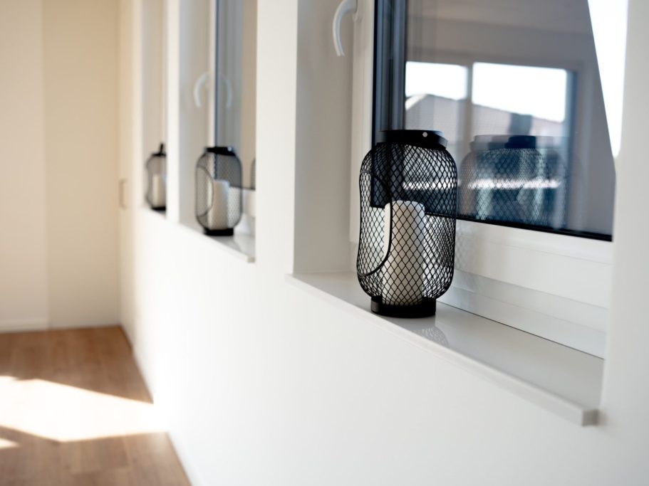 Moderne Fenster mit dekorativen schwarzen Lampen auf der Fensterbank.